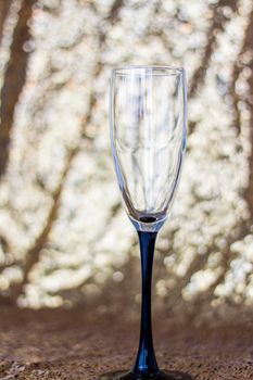 Glasses made of glass with black legs on a shiny background. Glitter background, champagne glasses