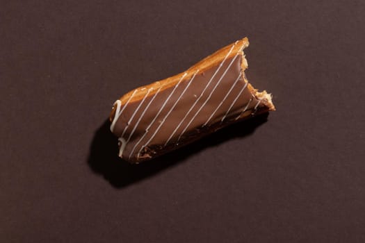 Chocolate eclair on a brown background top view