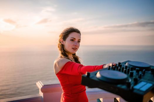 Female Hands of DJ plays music mixing and scratching on evening party. Professional music equipment. Close-up of a DJ console controlled by a young sexy woman. Selective focus.