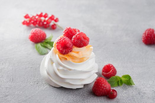 Pavlova dessert with berries on a gray background