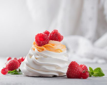 Pavlova dessert with berries on a gray background