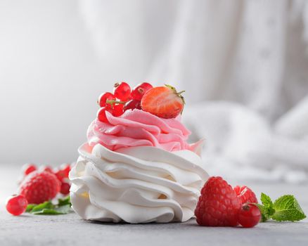 Pavlova dessert with berries on a gray background