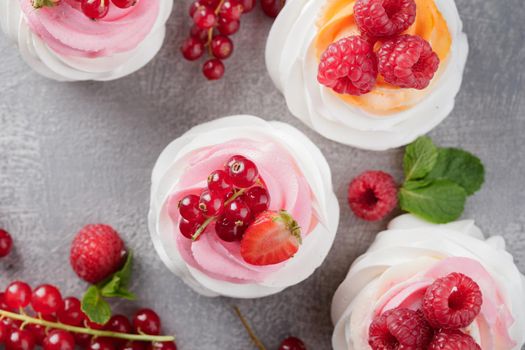 Pavlova dessert with berries on a gray background