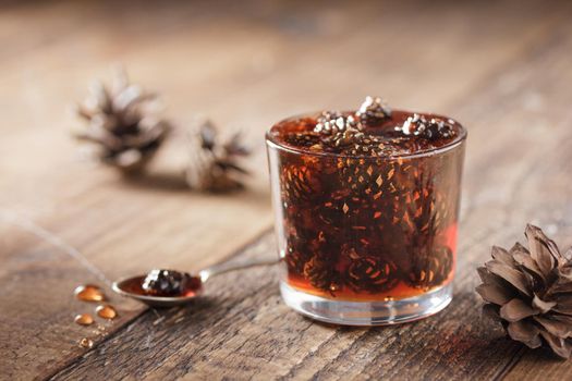 Delicious cone jam in a jar on a wooden background