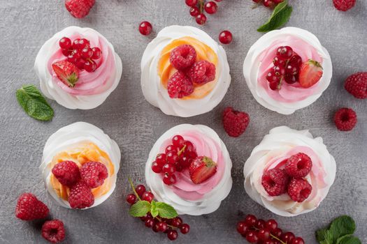 Pavlova dessert with berries on a gray background