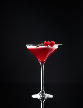 Cocktail in a glass on a black background vertical