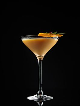 Cocktail in a glass on a black background vertical