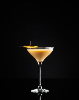 Cocktail in a glass on a black background vertical