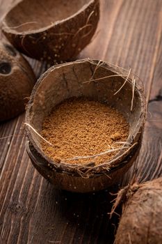 Coconut brown sugar in a coconut shell on a wooden background