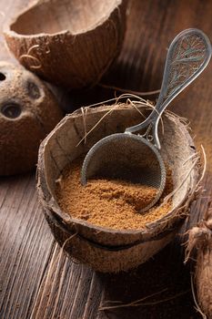 Coconut brown sugar in a coconut shell on a wooden background