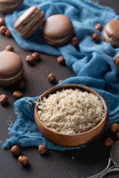 Chocolate macaroons with hazelnut flour on a blue textile