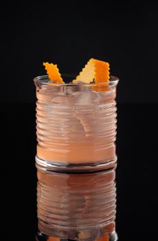 Cocktail in a glass on a black background vertical