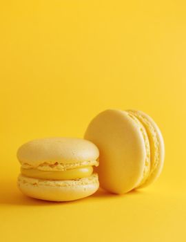 Lemon macaroons on a yellow background vertical