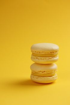 Lemon macaroons on a yellow background vertical
