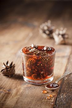 Delicious cone jam in a jar on a wooden background