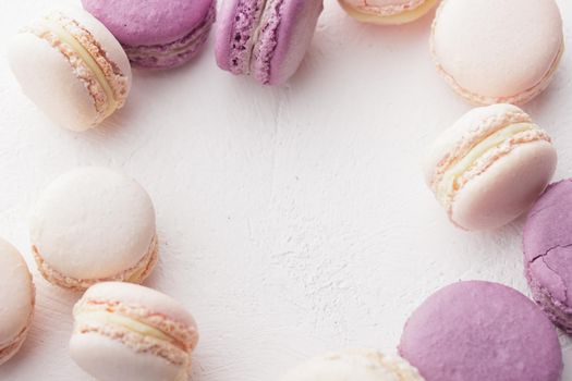 Pastel colored macaroons on a white background with copyspace