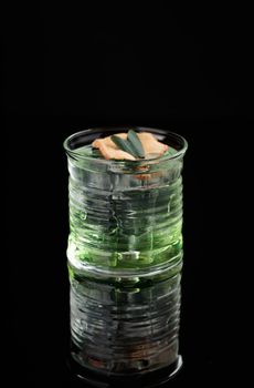 Cocktail in a glass on a black background vertical