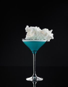 Cocktail in a glass on a black background vertical