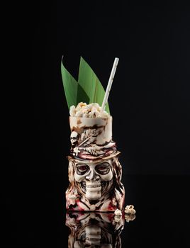 Cocktail in a glass on a black background vertical