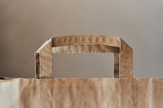 Eco-friendly paper bag. The handle of a paper bag. Banner. Zero waste. Recycled brown paper shopping bag with handle