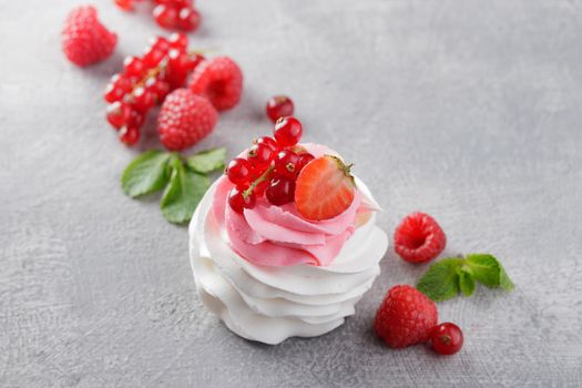 Pavlova dessert with berries on a gray background