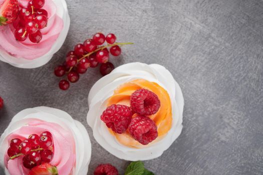 Pavlova dessert with berries on a gray background