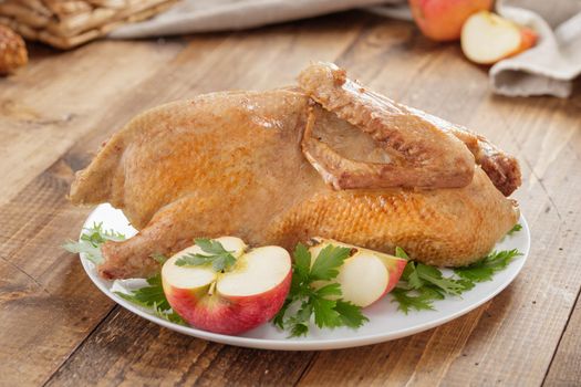Fried duck baked with apples on a wooden table