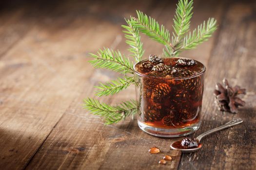Delicious cone jam in a jar on a wooden background