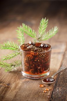 Delicious cone jam in a jar on a wooden background