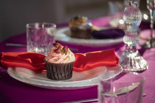 Pink and purple decoration and cupcakes on the table