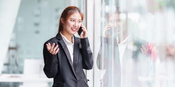 Portrait of Asian Business or Accountant woman talking with client by cell phone