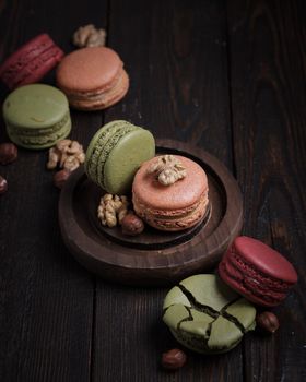 Pastel colored macaroons on a dark background with copyspace