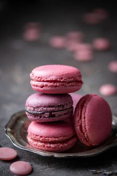 Pastel colored macaroons on a dark background with copyspace