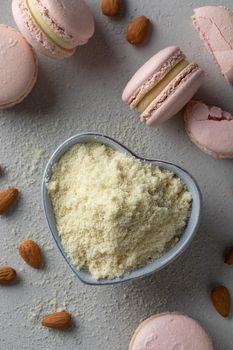 Pink macaroons with almond flour on a gray background