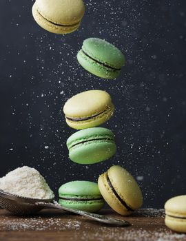 Pastel colored macaroons on a dark background with copyspace