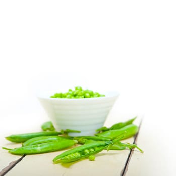 hearthy fresh green peas  over a rustic wood table