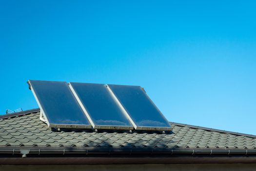 Three solar panels mounted on the roof and blue sky