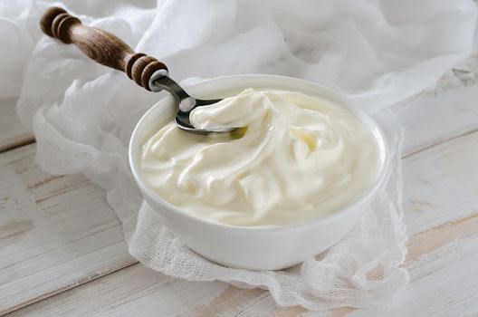 Greek yogurt on white wooden background