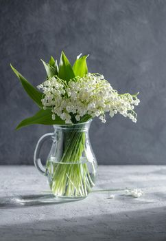 Lilies of the valley in a glass vase on a table