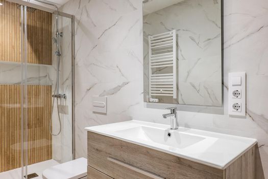 Interior of modern refurbished bathroom with shower with wooden finishing.