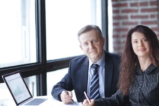 closeup.business woman and business partner sitting behind a Desk