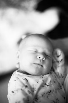 black and white photo in retro style.a pretty sleeping newborn baby . close up.