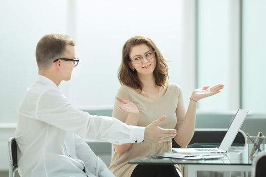 side view. business colleagues discuss something sitting at the Desk .business concept