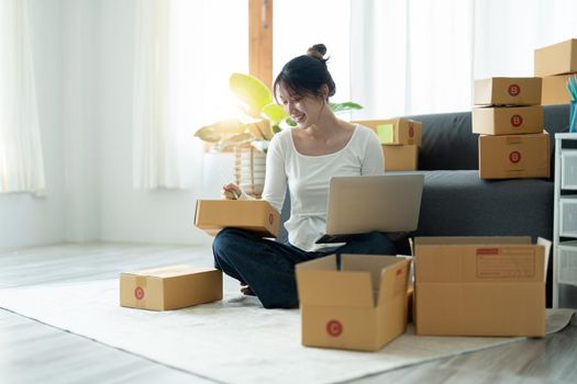 Portrait of Starting small businesses SME owners female entrepreneurs working on receipt box and check online orders to prepare to pack the boxes, sell to customers, SME business ideas online.