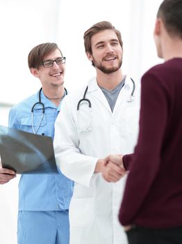 smiling doctor shaking hand of a patient.the concept of medical care