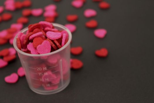 Red Pink Heart Candy in Transparent Cup Dark Background Love Valentine Concept.
