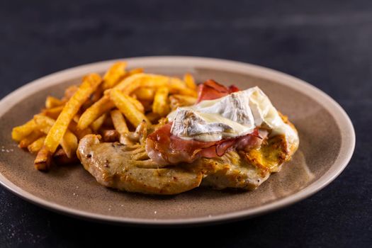 typical czech cuisine chicken slice baked with ham and camembert with french fries