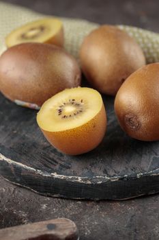 Kiwi on a black wooden board on a dark background