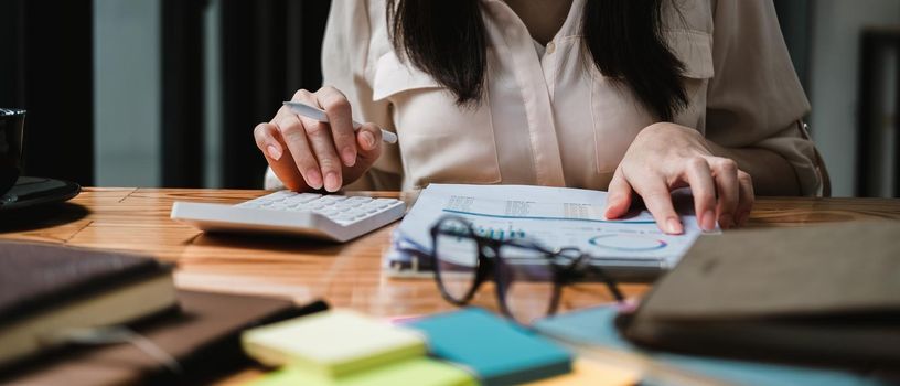 Close up a woman working about financial with calculator at his office to calculate expenses, Accounting concept