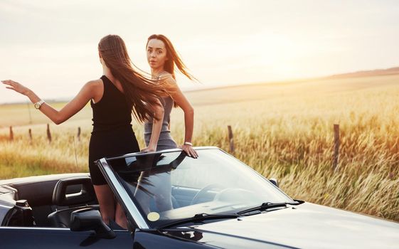 Two women in a black car on the roadside roads.